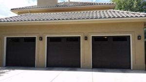 Three dark brown Carriage Style garage door with decorative windows